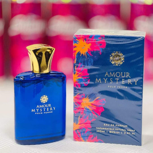Amour Mystery perfume bottle and packaging with a colorful floral design on a blurred background