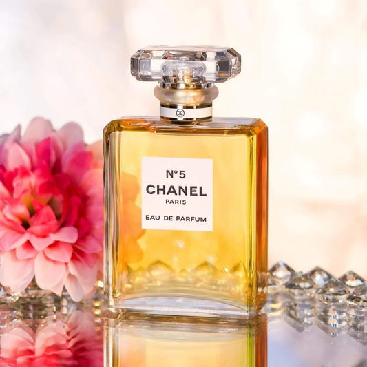 Chanel No. 5 perfume bottle with flowers and diamonds in the background