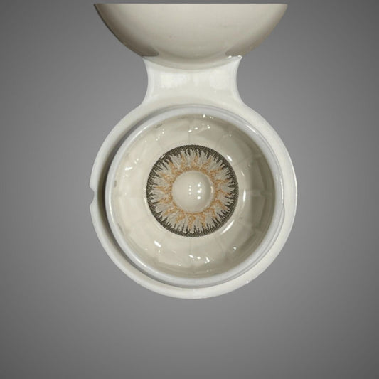 Close-up of a contact lens in a white container on a gray background at best price online sale in Pakistan