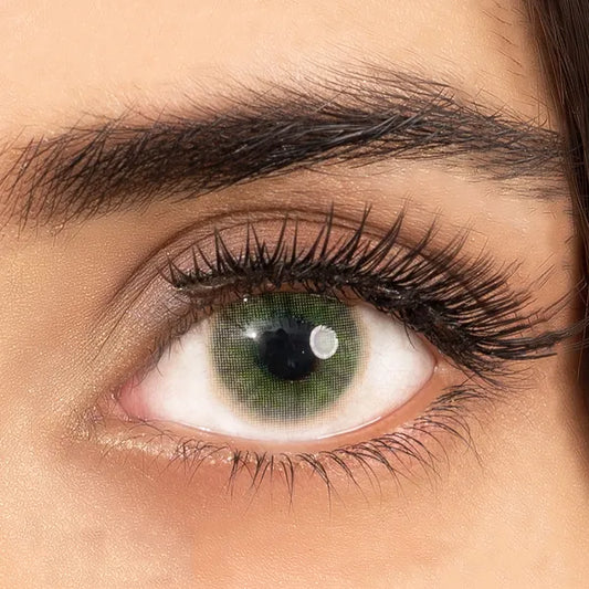 Close-up of an eye wearing green contact lenses of ultimate plus