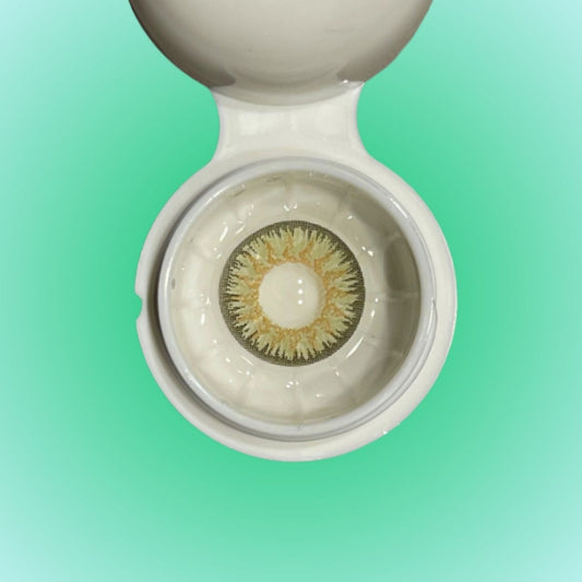 Close-up of a contact lens in a case with a green gradient background at best price online sale in Pakistan