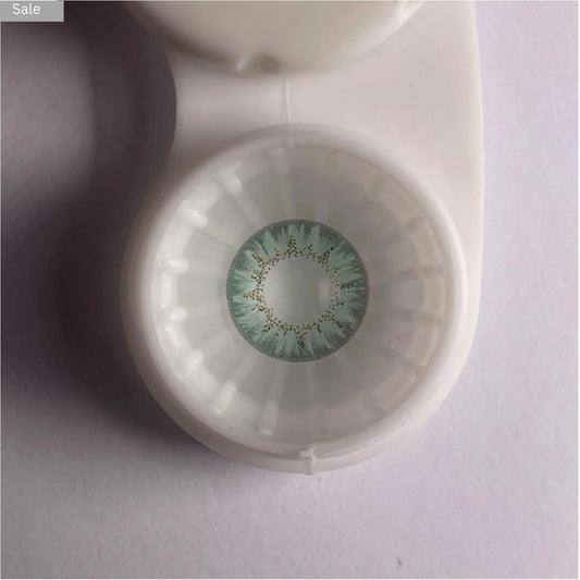 comfort Green contact lens in a container on a light gray background