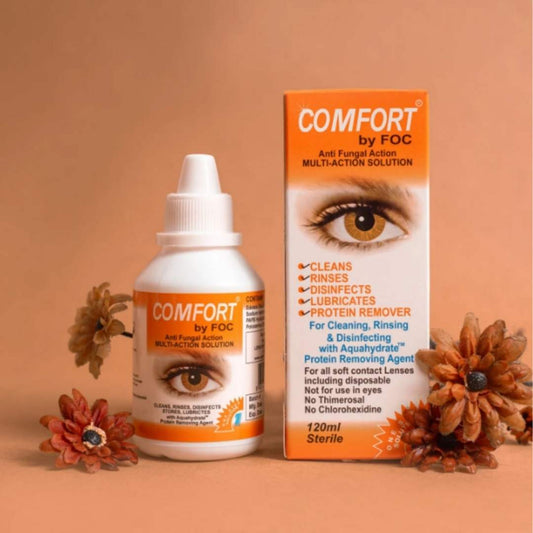 Buy comfort soft lenses solution at best price in Pakistan Maqbool Store online. Comfort by FOC eye solution bottle and packaging on a brown background with decorative flowers.