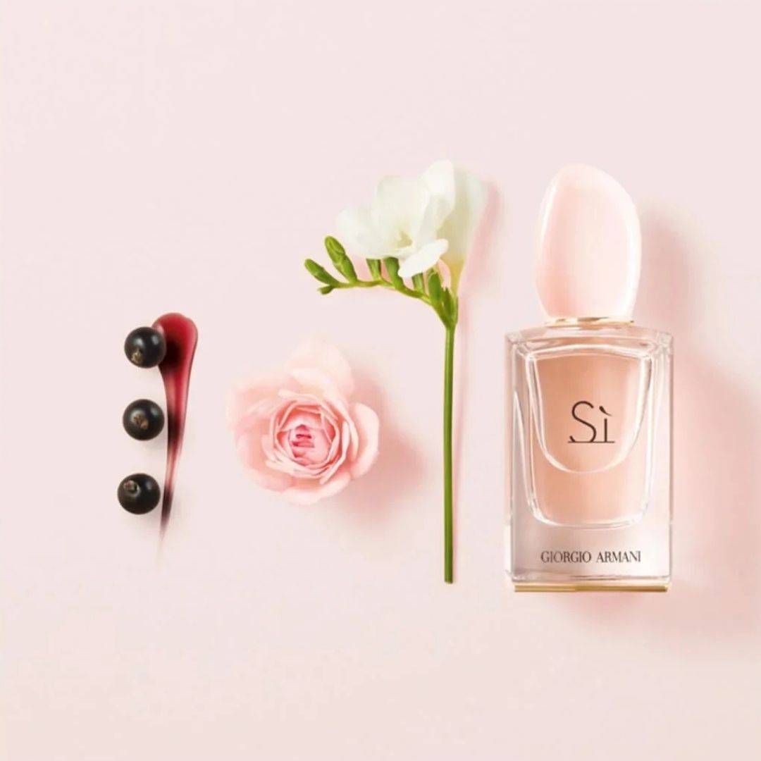 original Giorgio Armani Si perfume bottle with flowers and berries on a light pink background