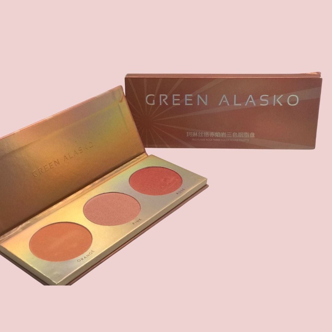 Makeup palette with three shades and packaging displaying 'Green Alasko' on a pink background
