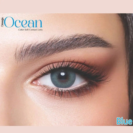 Close-up of an eye wearing blue contact lenses with 'Omega Ocean' branding.