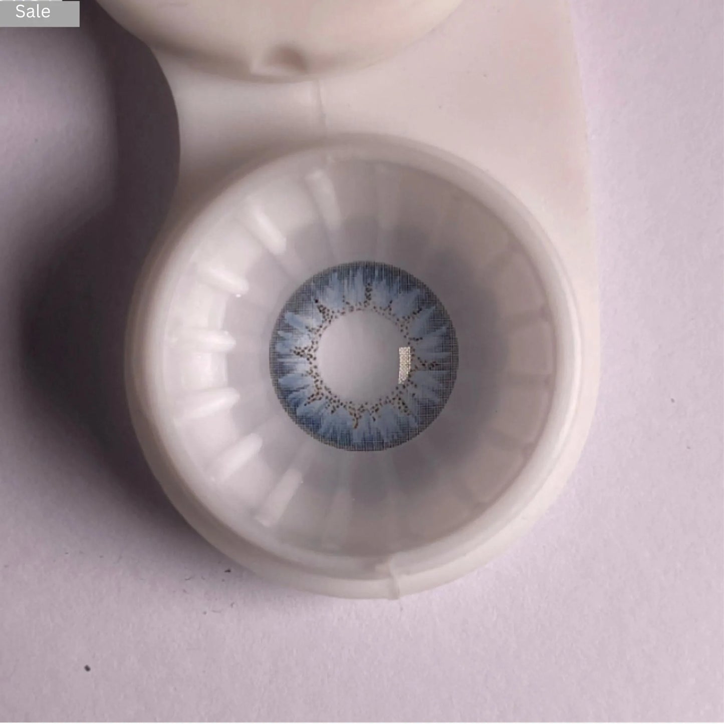 Pretty Seven Day Aqua contact Lenses in a clear case on a light gray background