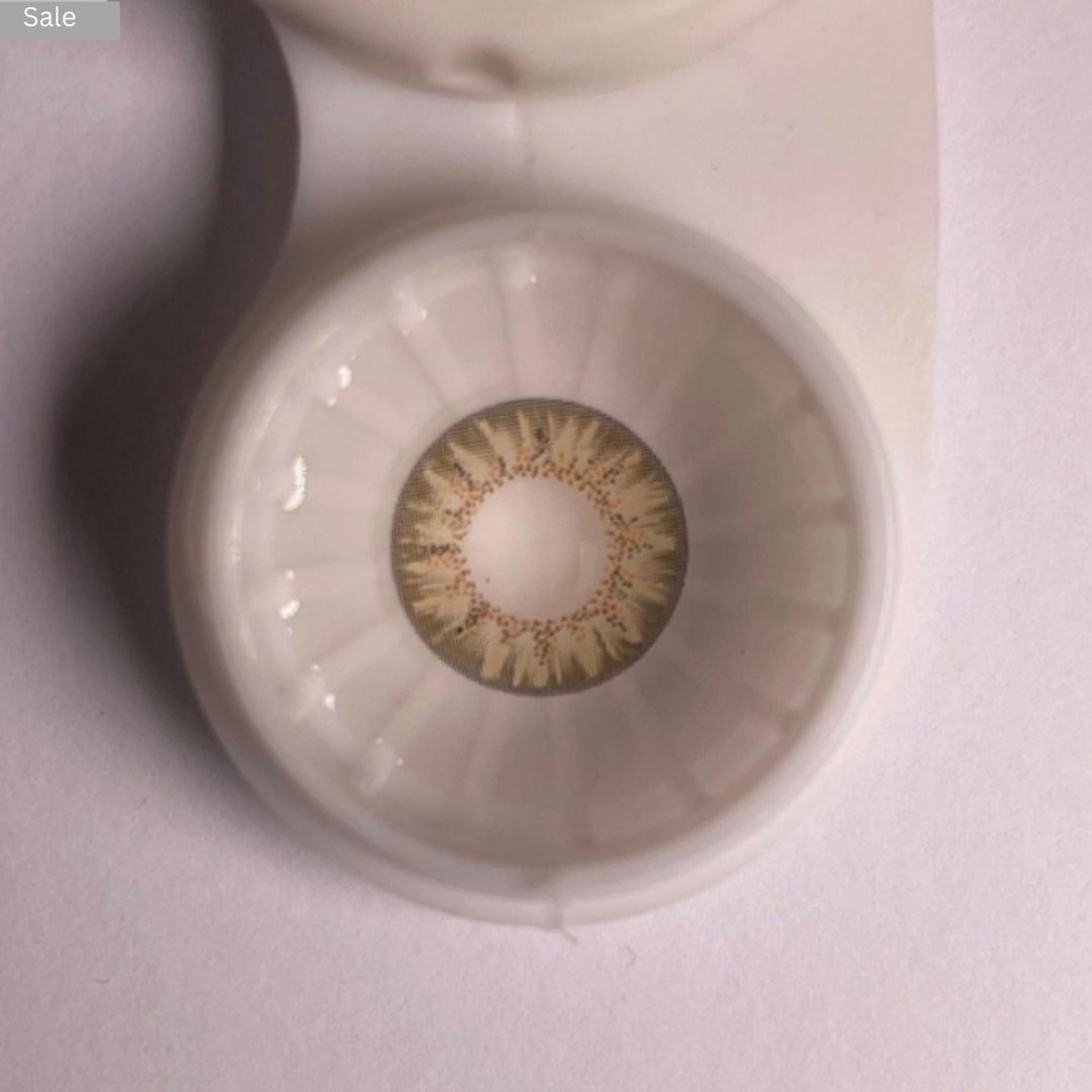 Close-up of a Pretty Seven Day Hazel contact lens in a case with a blurred background