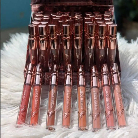 Set of Golden Rose lip glosses in a clear holder on a fluffy white surface.