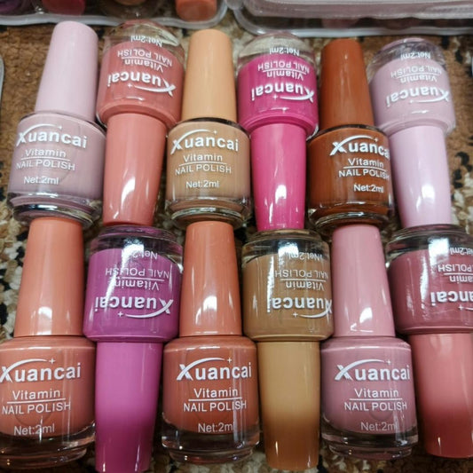 Collection of Xuancai nail polish bottles in various colors on a textured surface.