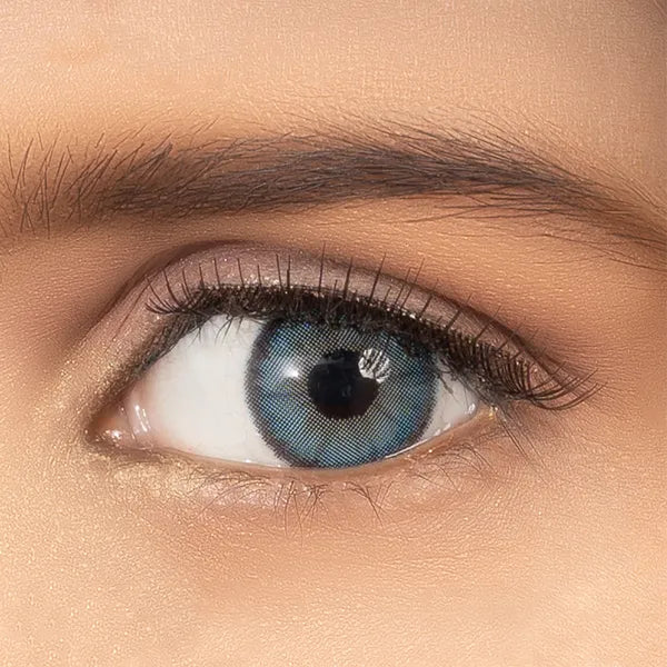 Close-up of an eye wearing blue contact lenses of ultimate plus