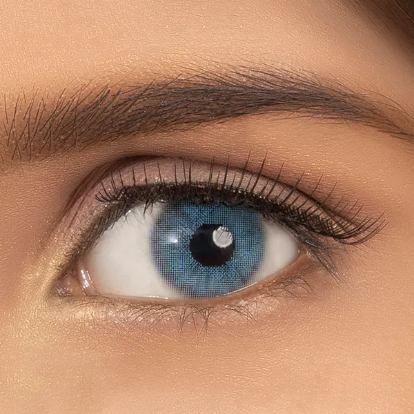 Close-up of an eye wearing blue contact lenses of ultimate plus