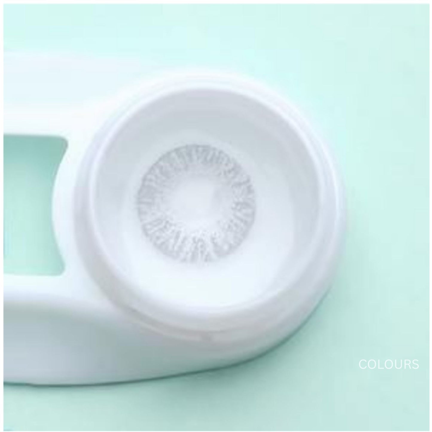 Close-up of a contact lens with a white case on a light green background at best price online sale in Pakistan