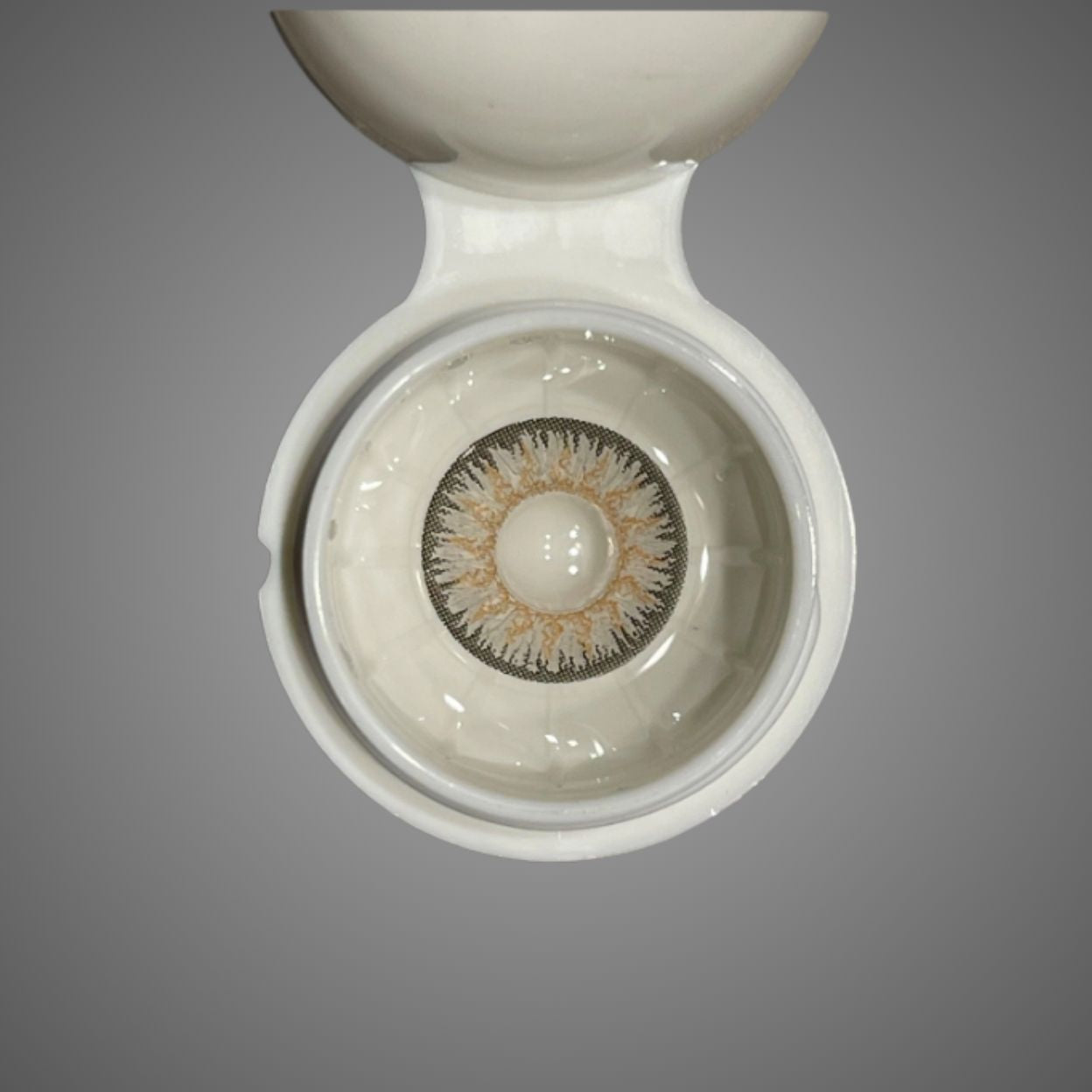 Close-up of a contact lens in a white container on a gray background at best price online sale in Pakistan