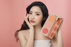 Woman holding a makeup product against a pink background at best price online sale in Pakistan