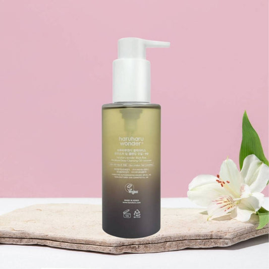 Skincare bottle with pump on a stone surface and pink background