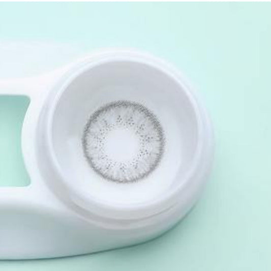 White contact lens case with contact lenses on a light green background at best price online sale in Pakistan