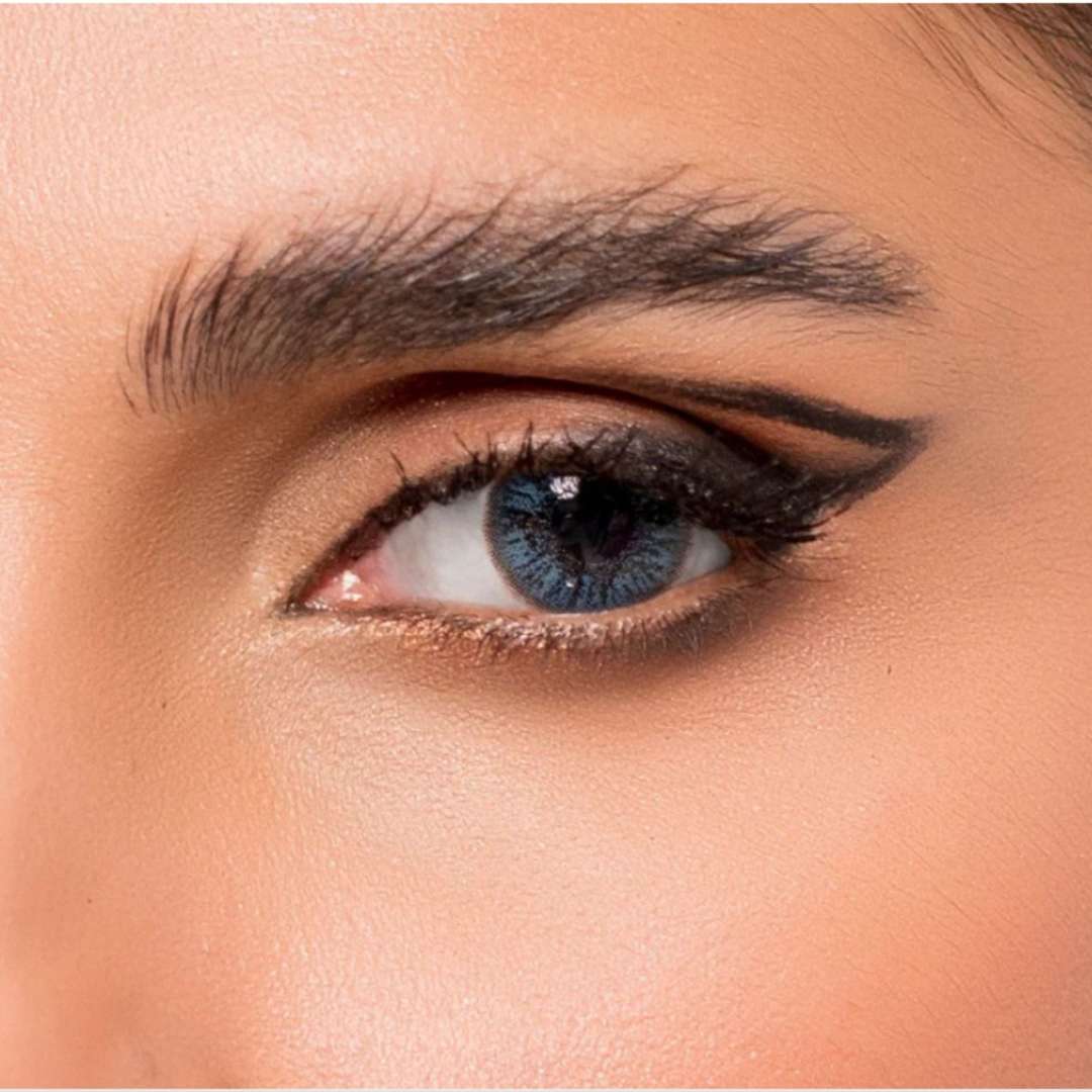 Close-up of a person's eye with blue jewel sky blue lenses