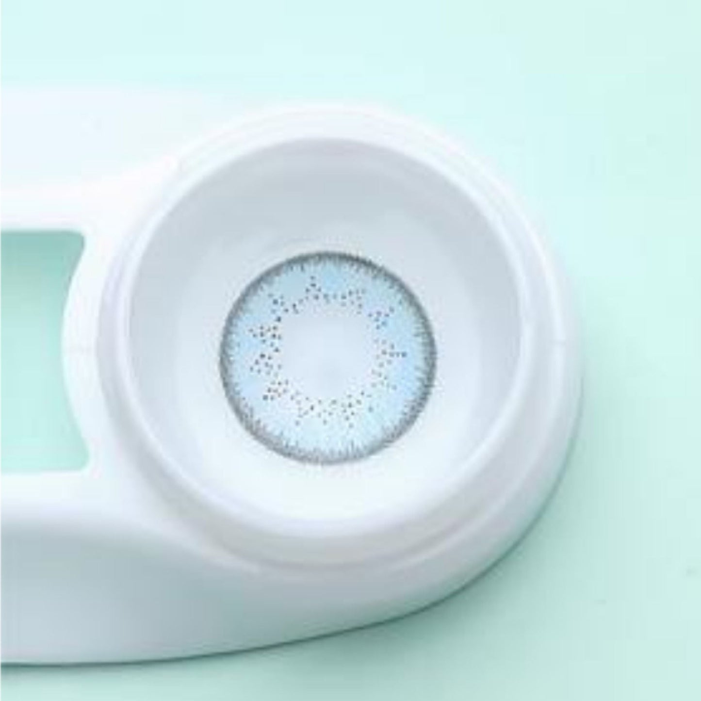 Contact lens with a case on a light green background at best price online sale in Pakistan