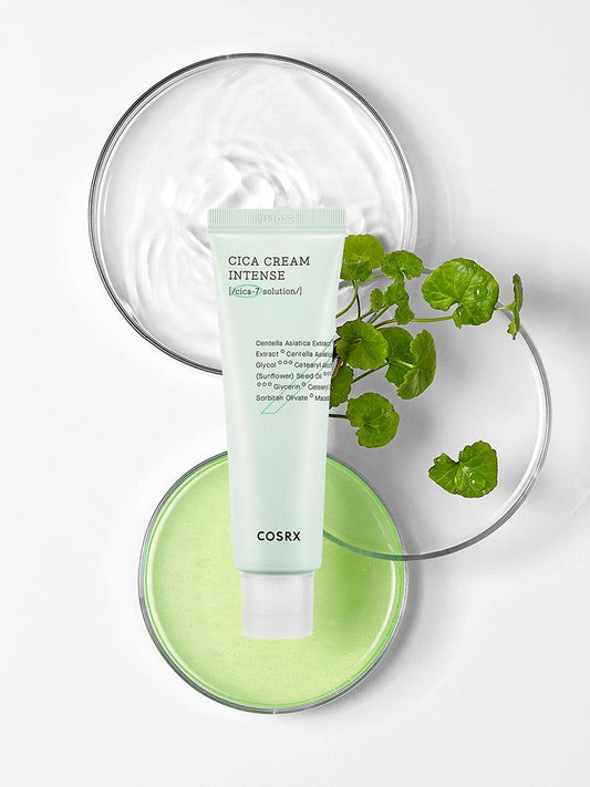 Cosrx Cica Cream Intense tube on a white background with a glass bowl and green leaves.