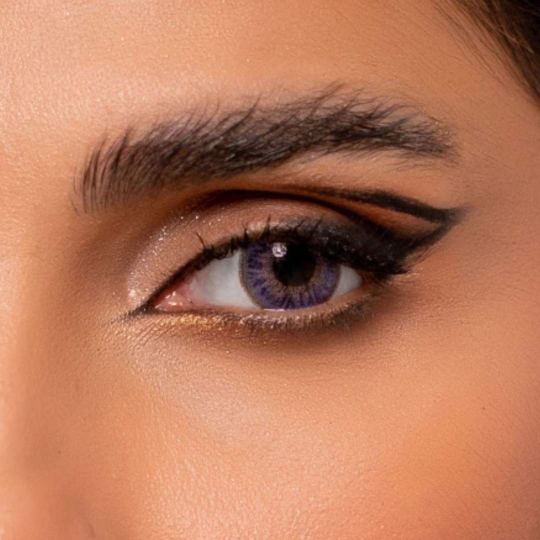 Close-up of a person's eye with rainbow violet contact lenses.