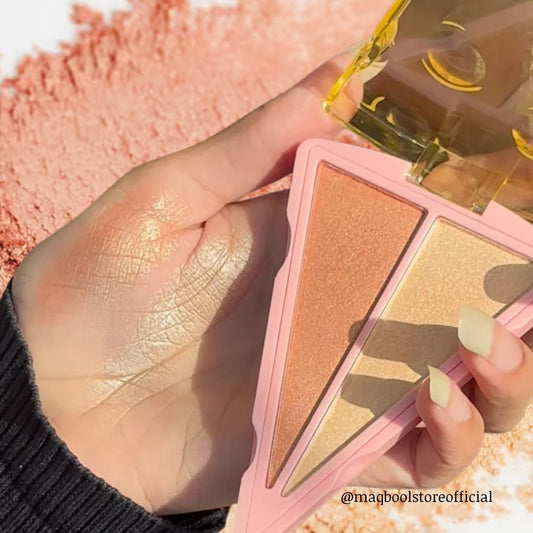 Hand holding a makeup palette with pink case and gold accents, surrounded by makeup products.