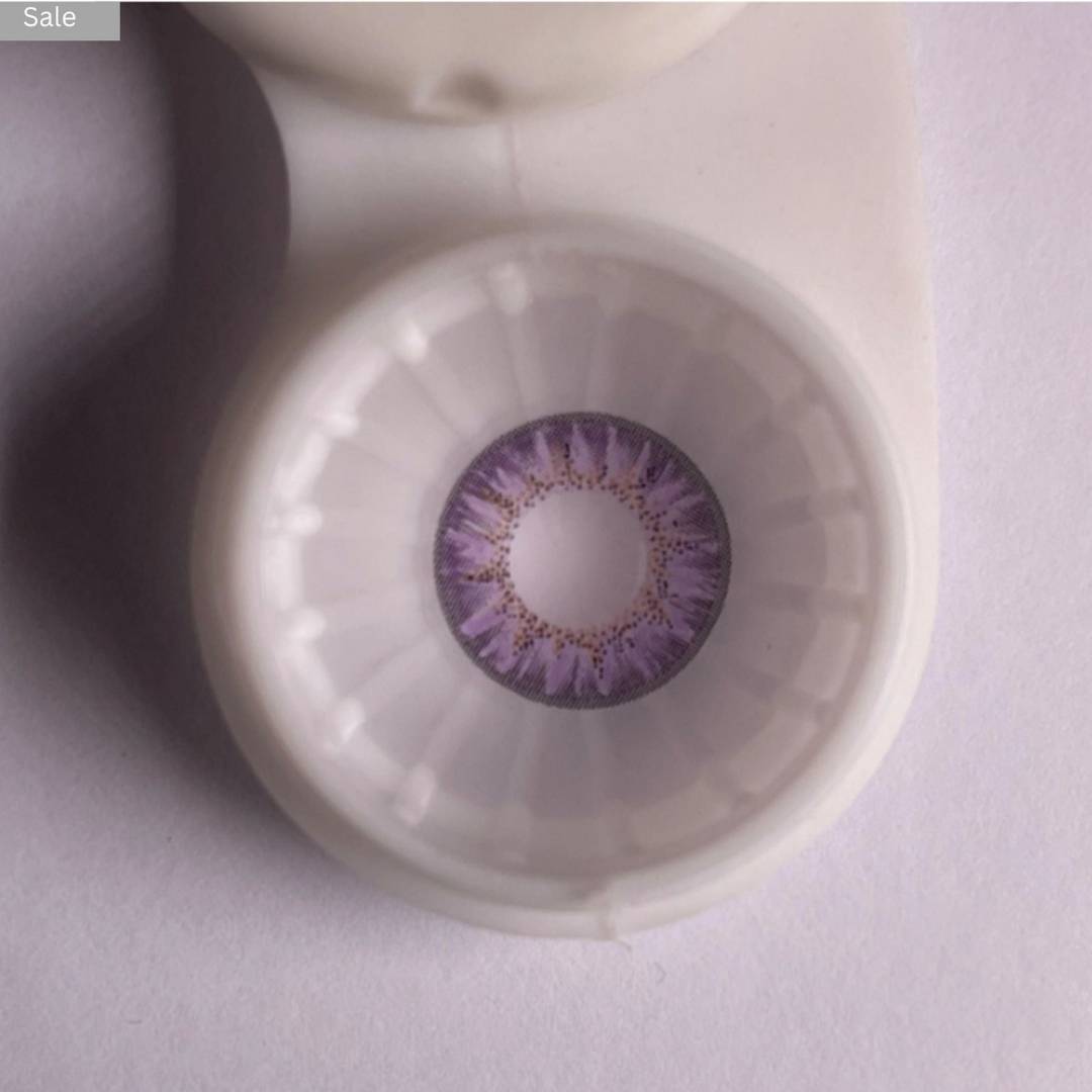 Close-up of a comfort purple contact lens in a container on a light gray background 