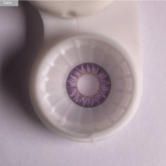 Close-up of a comfort purple contact lens in a container on a light gray background 